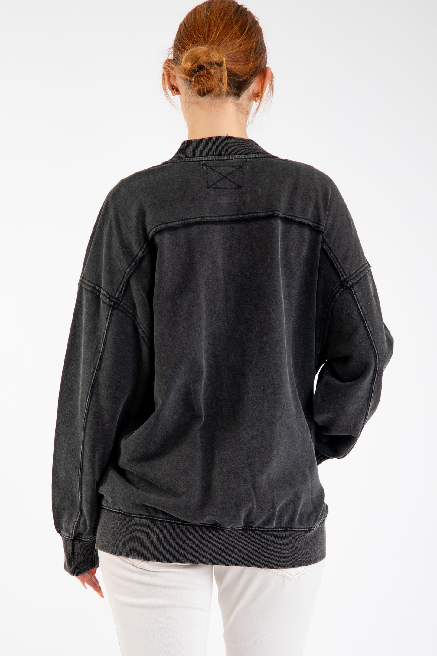 Woman wearing Birdie Washed Cotton Exposed Seam Bomber Jacket with zipper closure and side pockets