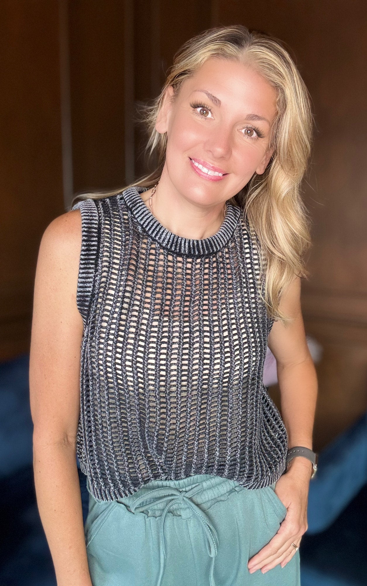 Black Yolanda fishnet sweater vest layered over tank top

