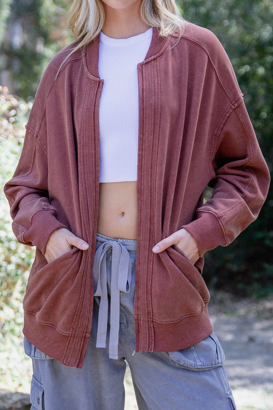 Woman wearing Birdie Washed Cotton Exposed Seam Bomber Jacket with zipper closure and side pockets